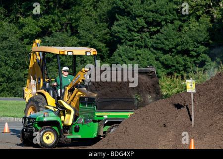 Déménagement mulch avec un tracteur John Deere et véhicule utilitaire. Banque D'Images