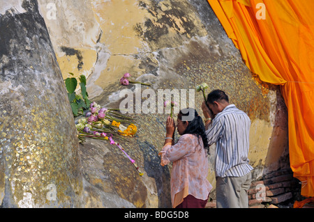 Les croyants bouddhistes devant une statue de Bouddha couché, transition vers le nirvana, Wat Lokayasutha, Ayutthaya, Thaïlande, Asie Banque D'Images