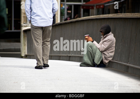 Un mendiant sur le Millennium Bridge sur la rivière Liffey, Dublin, République d'Irlande Banque D'Images