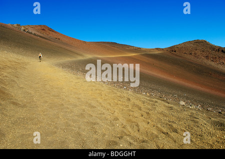 Randonneur sur le sentier des sables bitumineux coulissante dans le Cratère de Haleakala ; Parc National de Haleakala, Maui, Hawaii. Banque D'Images