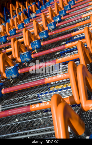 Rangée de shopping trollies enchaînés à l'extérieur d'un magasin supermarchés sainsburys en Angleterre Banque D'Images