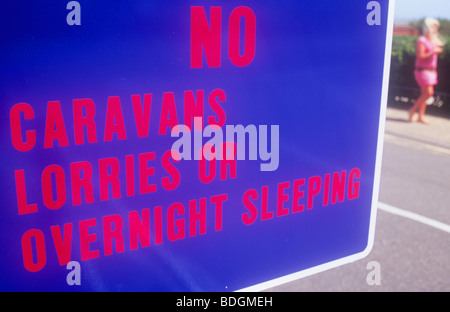 Détail de l'affiche rouge et bleu luminescent indiquant pas de caravanes de camions ou de dormir la nuit et avec femme marche par Banque D'Images