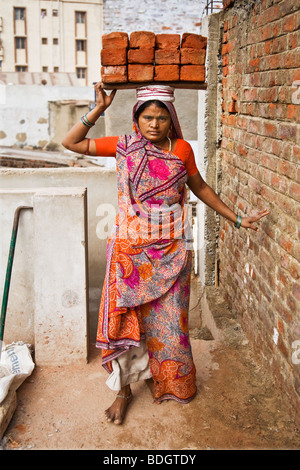 Des femmes portant des briques sur la tête. Elle travaille sur un chantier dans une ville de l'Inde. Ces femmes sont les bas salaires. Banque D'Images