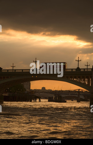 Double decker bus rouge anglais passant Thames bridge au coucher du soleil Londres Angleterre Europe par temps nuageux, les rayons de lumière Banque D'Images
