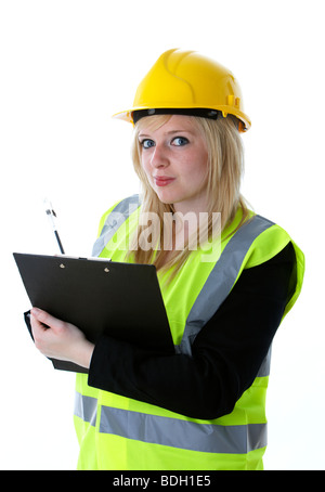 jeune femme blonde de 20 ans portant un casque jaune et un gilet haute vis écrivant sur un presse-papiers avec contact visuel prenant des notes observant le manager Banque D'Images