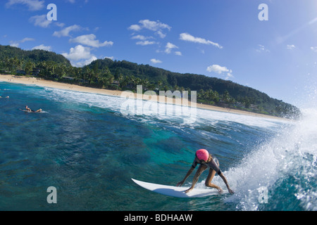 Un grand angle, le fisheye view of a woman surf au pipeline, sur la côte nord d'Oahu, Hawaii. Banque D'Images