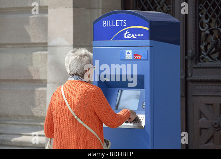 Femme âgée à un distributeur de billets, Strasbourg, France Banque D'Images