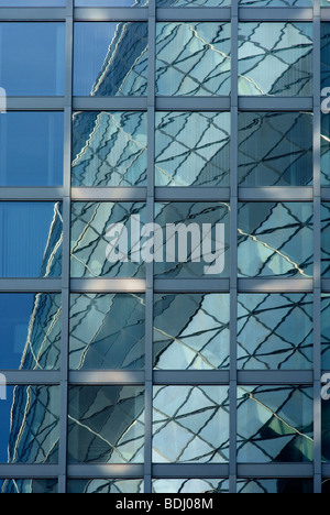 Réflexions du 30 St Mary Axe dans les fenêtres d'une tour adjacente Banque D'Images