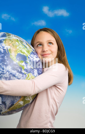 Little Girl Holding un modèle de Terre vue de l'espace extra-atmosphérique Banque D'Images