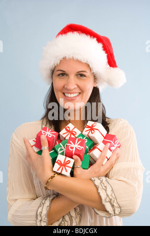 Woman Wearing Santa Hat Cadeaux de Noël miniature Banque D'Images