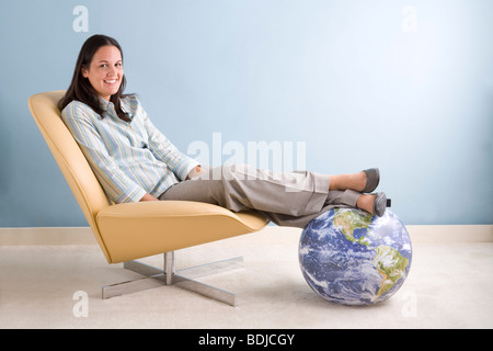 Man avec ses pieds sur un globe Banque D'Images