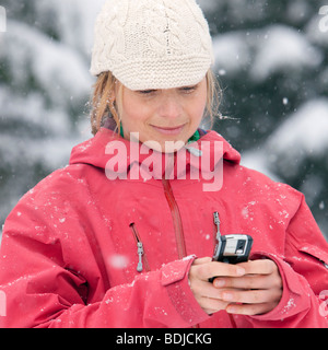 Close-up of Woman Using PDA à l'extérieur en hiver, Whistler, British Columbia, Canada Banque D'Images