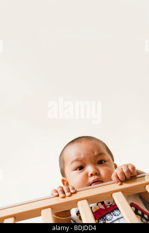 Baby Holding sur Rambarde de lit-bébé Banque D'Images