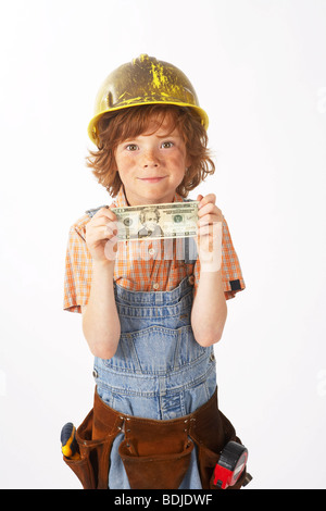 Garçon habillé en Construction Worker Holding Argent Banque D'Images