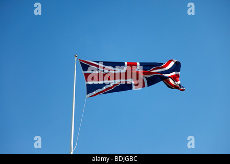 Le climat, le vent, drapeaux, British Union Jack drapeau à la brise contre le ciel bleu. Banque D'Images