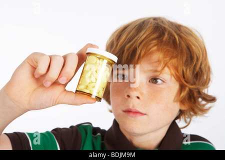 Garçon à la recherche de bouteille de pilules Banque D'Images