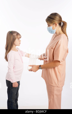 Nurse Wrapping bandage autour du bras de la jeune fille Banque D'Images