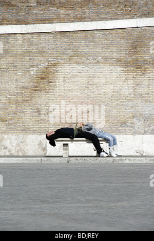 Couple lying on bench in piazza del Popolo, Rome Banque D'Images