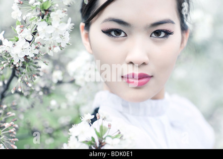 Jeune femme avec des fleurs de cerisier. Effet dof peu profondes. Banque D'Images