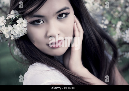 Jeune femme avec des fleurs de cerisier. Effet dof peu profondes. Banque D'Images