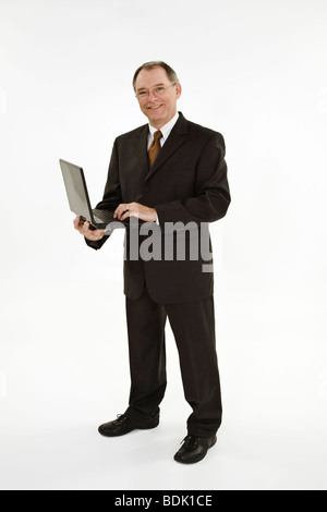 Un caucasian businessman avec un délié de recul portant un costume noir et chemise blanche. Banque D'Images