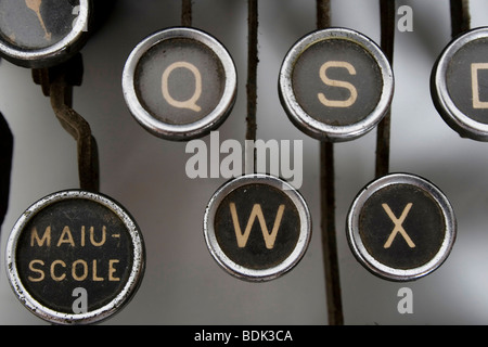 Touche noire avec lettres d'or d'une vieille machine à écrire, célèbre lettre en majuscule. Banque D'Images