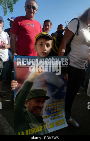 Jeune garçon tenant une affiche célébrant la révolution cubaine à l'Internationale des travailleurs Mars, La Havane, Cuba. 1 mai 2009 Banque D'Images