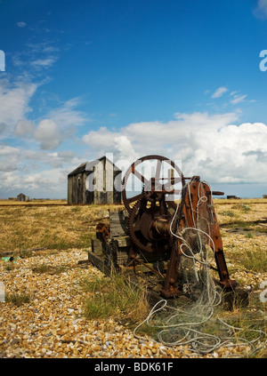 Rusty abandonnés les machines et cabanes de bois sur la plage de galets à Dungeness, dans le Kent. Banque D'Images