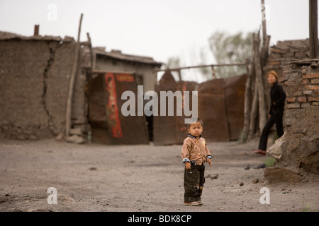 Un jeune garçon devant son domicile près de la charbon Wuda champ près de Wu Hai, en Mongolie Intérieure Banque D'Images