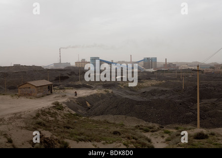 Un mineur conduit sa moto à travers le paysage de la spoliation du charbon Wuda champ près de Wu Hai, en Mongolie Intérieure Banque D'Images