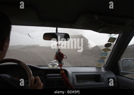 Un chauffeur suit un camion de charbon grâce à la poussière de charbon du terrain houiller de Wuda près de Wu Hai, en Mongolie Intérieure Banque D'Images