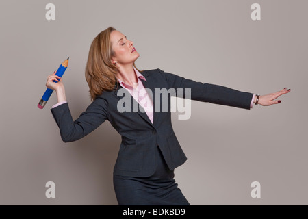 Businesswoman throwing un crayon comme une lance ou javelot Banque D'Images