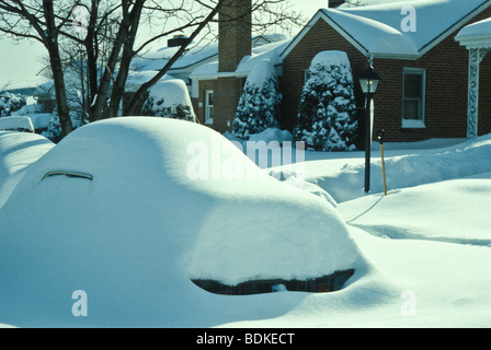 Voiture couverte de neige mouillée dans le quartier de banlieue. Banque D'Images