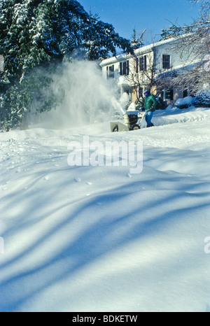 Avec l'entrée de banlieusard homme efface machine de soufflage de la neige La neige lourde suivant l'outil. Banque D'Images