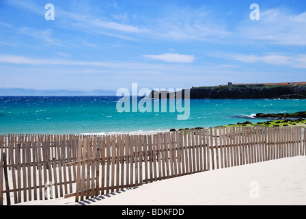 Plage de sable de Tarifa avec du sable en barrières contre le ciel bleu et la mer bleu-vert Banque D'Images