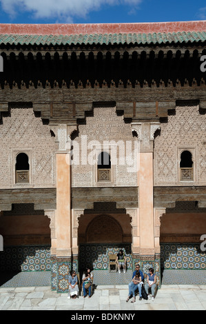 Visiteurs ou touristes dans la cour de la Medersa Ali ben Youssef (école islamique c14e), Marrakech, Maroc Banque D'Images