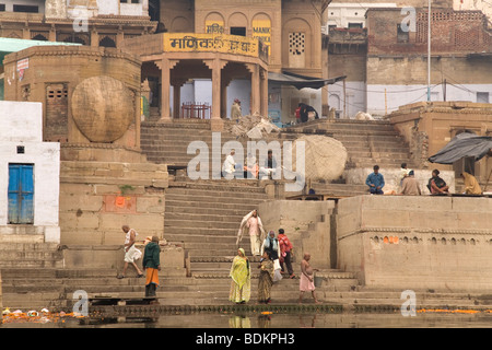 Les gens se lever et s'asseoir sur les ghats du Ganga (le Gange) river à Varanasi, Inde. Banque D'Images