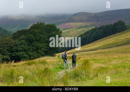 Deux marcheurs sur la section pavée du Pennine Way, de Edale jusqu'à Kinder Scout, parc national de Peak, Derbyshire, Angleterre, Royaume-Uni Banque D'Images