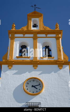 Clocher jaune et blanc avec trois cloches d'une église typique contre le ciel bleu à Cordoue, Andalousie, Espagne, Europe Banque D'Images