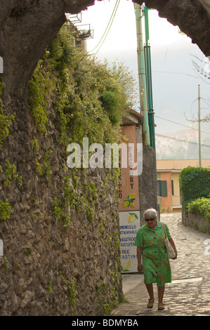 Vieille dame à monter rue pavée par une usine de limoncello, Ravello, Campanie, Italie Banque D'Images