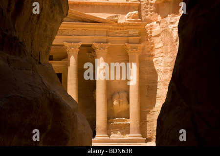 Le Conseil du Trésor vu à travers le siq, un canyon étroit chemin à travers des falaises rocheuses, à Pétra. Banque D'Images