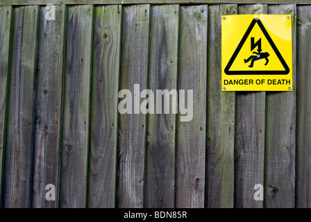 Danger de mort signe sur une clôture en bois entourant une sous-station électrique, à Kew, au sud-ouest de Londres, Angleterre Banque D'Images