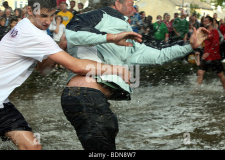 Un spectateur envahit le terrain au cours de la match de football annuel tenu dans la rivière Windrush Kingham Banque D'Images