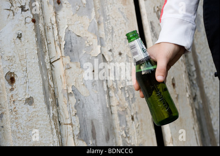 Close up d'une bouteille de bière étant détenu par une adolescente Banque D'Images