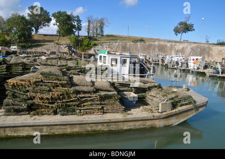 Bateaux d'huître, chargé avec des sacs d'huîtres, amarré dans le petit port ostréicole du Château d'Oléron, côte Atlantique. La France. Banque D'Images