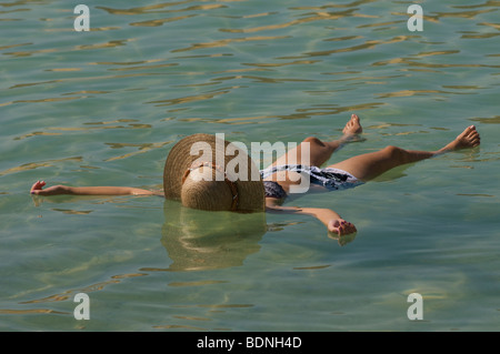 Un touriste flottant sur le dos à l'eau salée de la mer Morte Israël Banque D'Images