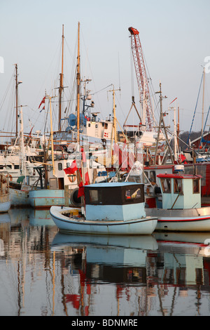 Dans l'atmosphère du soir dans le nord du port de Skagen (Danemark). Réflexions des bateaux dans l'eau. Banque D'Images