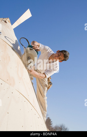 Menuisier travaillant sur la tourelle d'une maison Banque D'Images