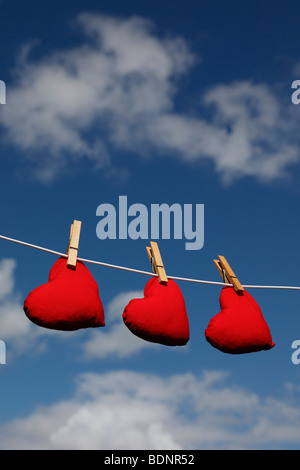 Sacs de fèves en forme de coeur sur une ligne de lavage contre un ciel d'été (version sans nuages - Ref BDN1TT) Banque D'Images