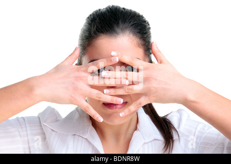 Brunette woman regarder à travers ses doigts, isolé sur un fond blanc. Banque D'Images